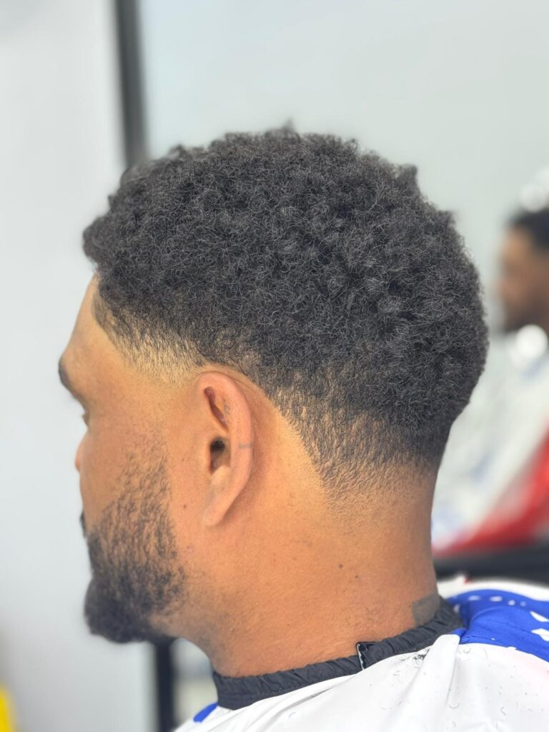 Taper fade on curly hair with a shaped beard