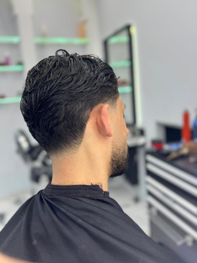 Low taper with textured hair, seen from the back