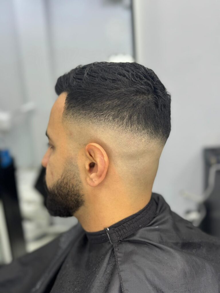 High skin fade with a short top and full beard